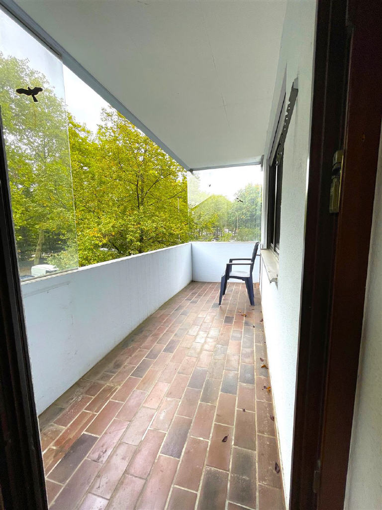 Wohnzimmer mit Zugang zur Küche und zum Balkon